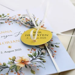 Einladungskarte zur Hochzeit mit Blütenkranz und rundem Anhänger