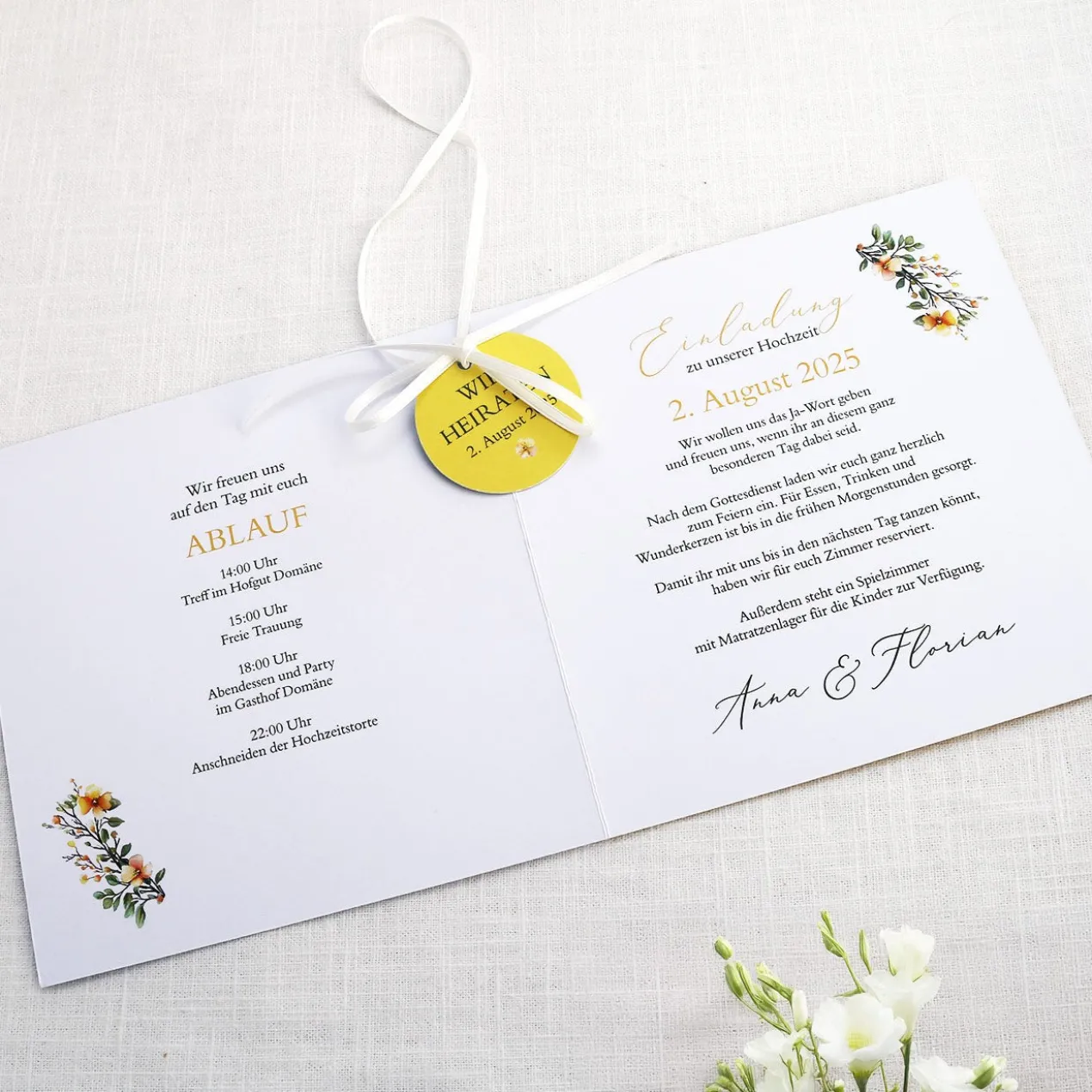 Einladungskarte zur Hochzeit mit Blütenkranz und rundem Anhänger