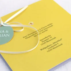 Einladungskarte zur Hochzeit mit Blütenkranz und rundem Anhänger