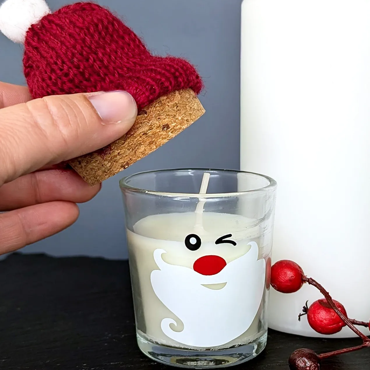 Kerze im Glas mit Korken und Pudelmütze im Santa-Design